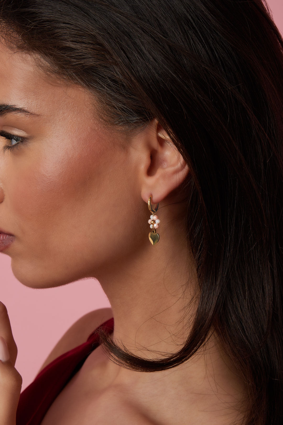 Boucles d'oreilles avec un cœur sur une fleur perlée
